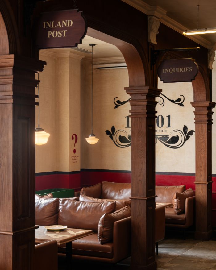 Signage for Inland Post and Inquiries and a run of leather booths under warm pendant lights