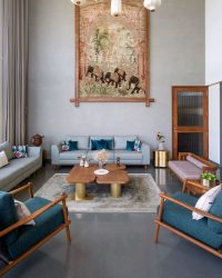 Teal and timber tones define the seating area, layered with cushions and subtle textures that bring depth to the space. Curated artwork punctuates the walls, creating a calm, inviting corner that feels both refined and lived-in; Photography by MK Gandhi