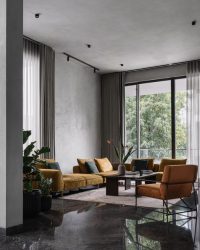 The living room revolves around an accent couch by Empire Home and a chair in a similar palette by Elevate X, all atop a carpet from Hands; Photography by Ishita Sitwala