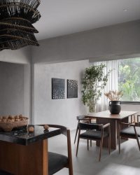 Lime plaster walls and Rangoli matte grey tiles set the stage for Ek Design’s dining and bar furniture. A hanging light from Orange Tree and Altrove’s vases, candle stands and pillows bring texture, warmth and character to the space; Photography by Sagar Mandal
