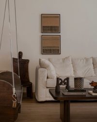 The 80-year-old Burma teak swing hangs elegantly in the living room, beside a fellow antique find – the Naga chair, artwork by Peaony; Photography by Noaidwin Sttudio