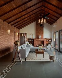The living room features a natural palette of browns and whites, with chairs from Gulmohar Lane, a fan by Anemos, and lighting curated from The Hesperus Store; Photography by Hemant Patil